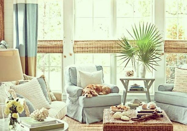 coastal living space with blue linen chairs and rattan coffee table